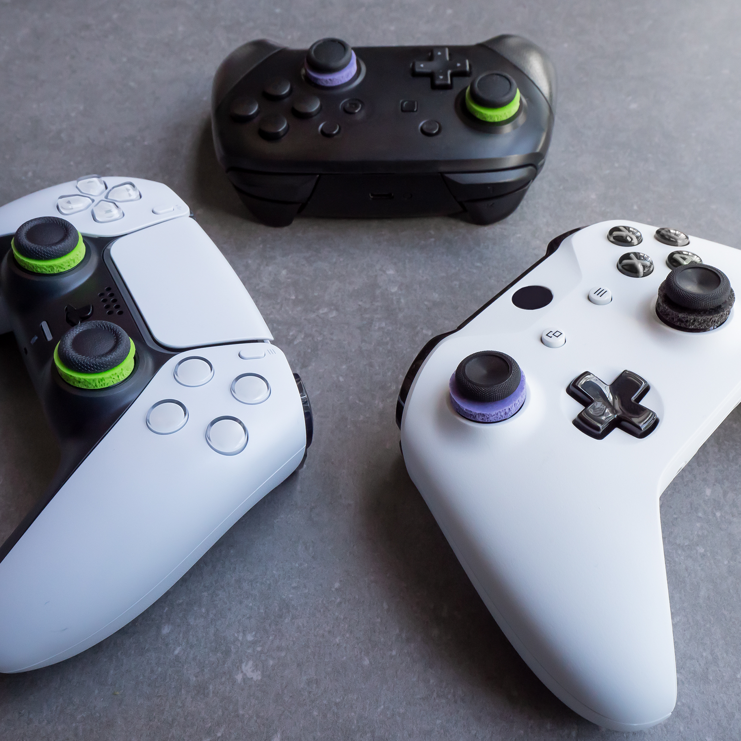 Three game controllers: black, white, and white.