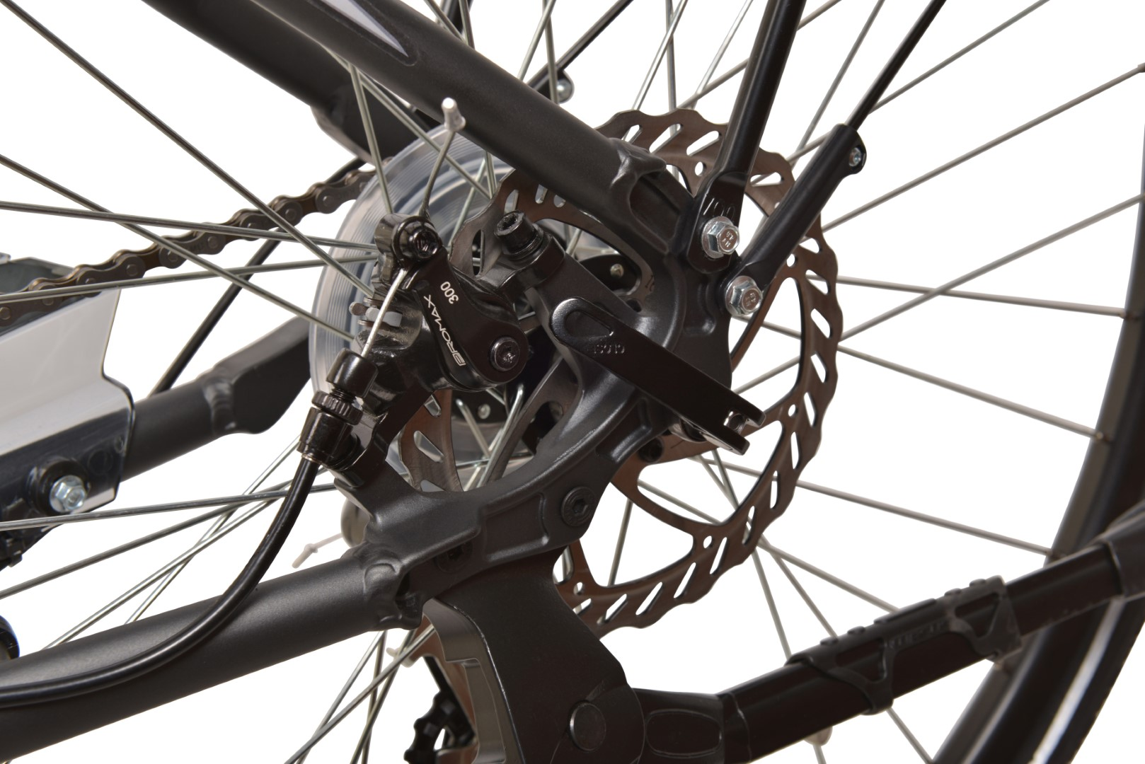 Zbliżenie na tylne koło roweru z hamulcem tarczowym i widocznymi biegami.