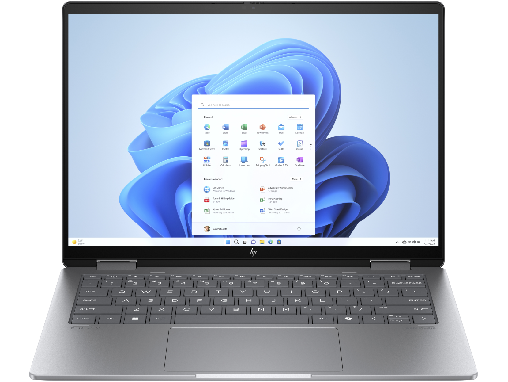 Un portátil plateado, abierto, mostrando Windows 11 en pantalla.