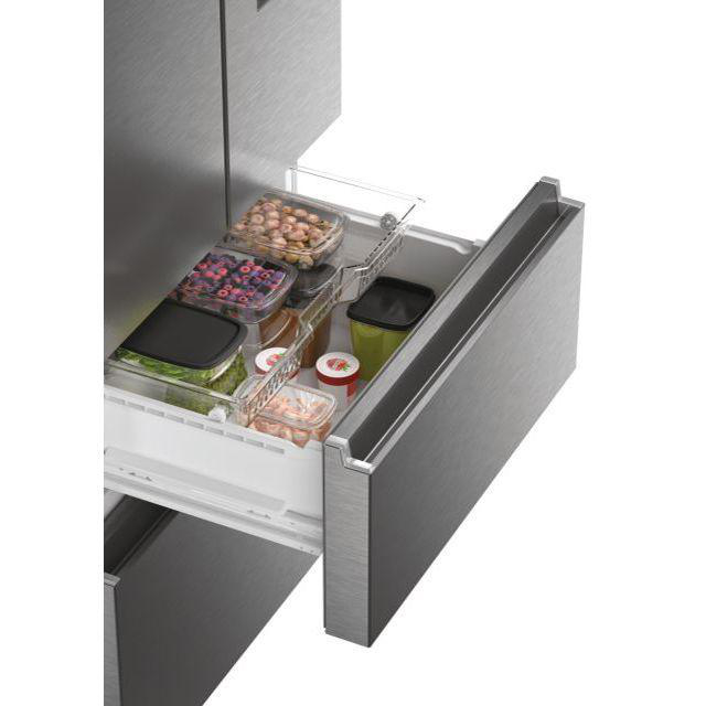 Geöffnete Kühlschublade mit Lebensmittelbehältern: Beeren, Nüsse und Gemüse. Metallisch-graue Schublade und Kühlschrank.
