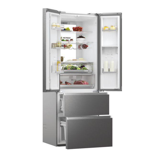 Offener Kühlschrank mit Lebensmitteln. Obst, Gemüse und andere Artikel sind auf den Regalen sichtbar. Zwei untere Schubladen sind offen.