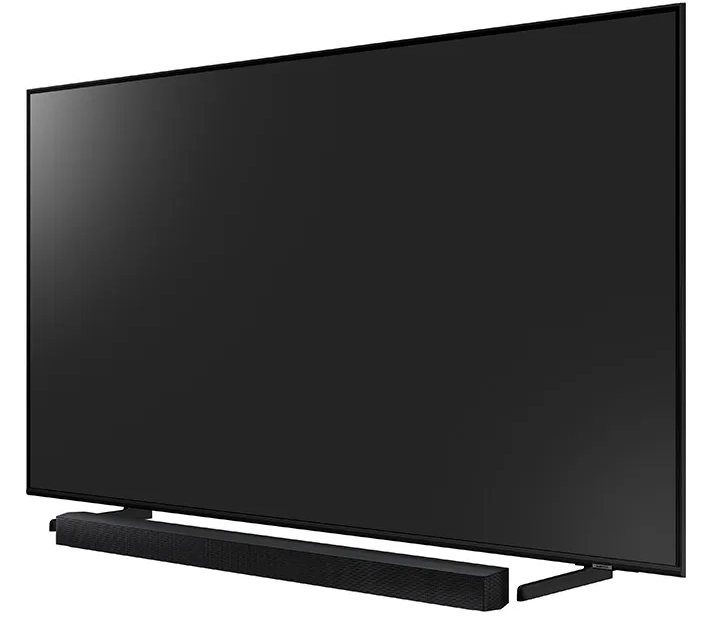 Duży czarny ekran telewizora z soundbarem poniżej i stojakiem. Ekran jest włączony.