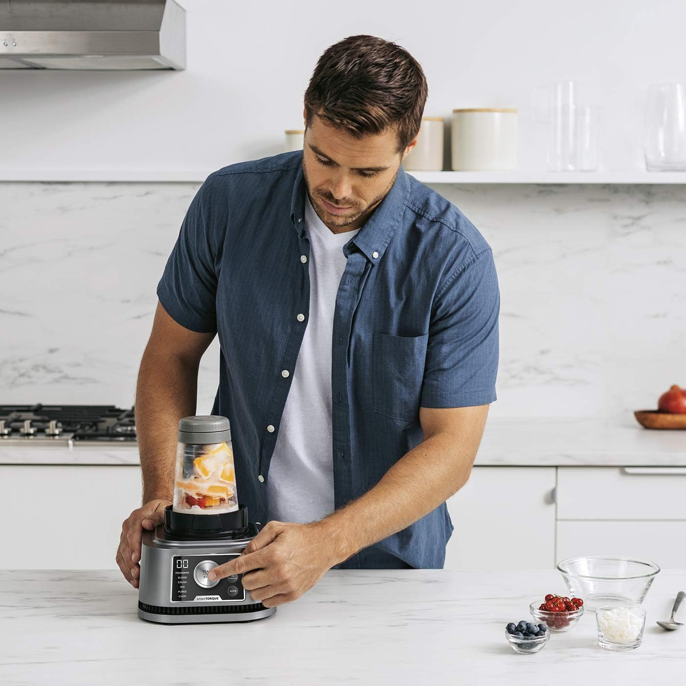 Homme utilisant un mixeur. Cadre de cuisine. Comptoir avec ingrédients.