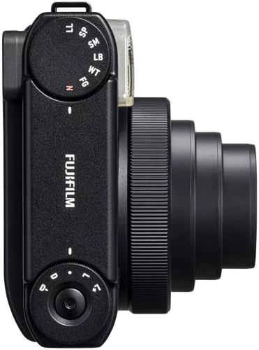 Fekete Fujifilm kamera, oldalsó nézetben, objektívvel és beállításokkal. Fehér háttér.