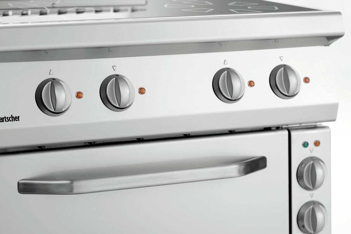 Nahaufnahme eines Edelstahlelektroherds mit vier Knöpfen und einem Ofengriff.