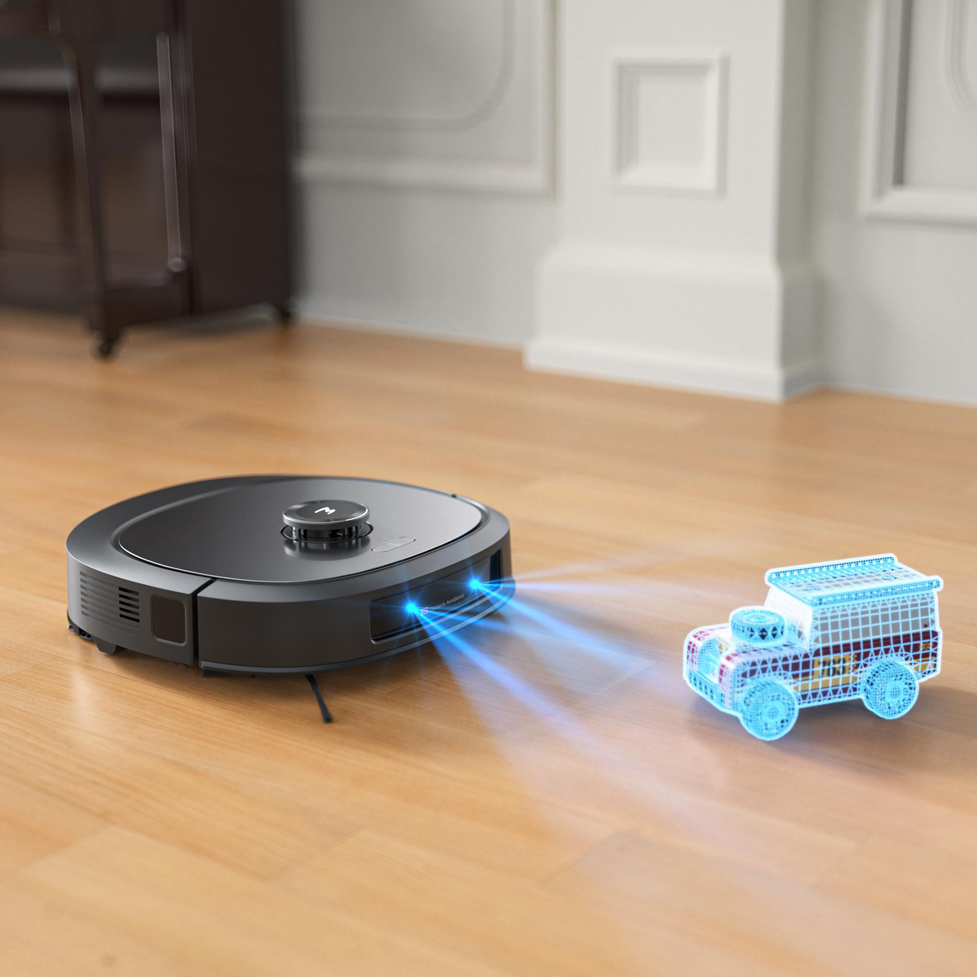 Ein Roboter-Staubsauger und ein lichtprojiziertes Automodell auf einem Holzboden.