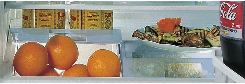 All'interno di un frigorifero con arance, burro, un piatto di cibo e una bottiglia di cola.