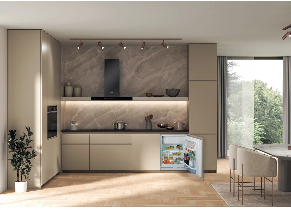 Cucina con mobili beige, frigo aperto e sfondo in marmo.