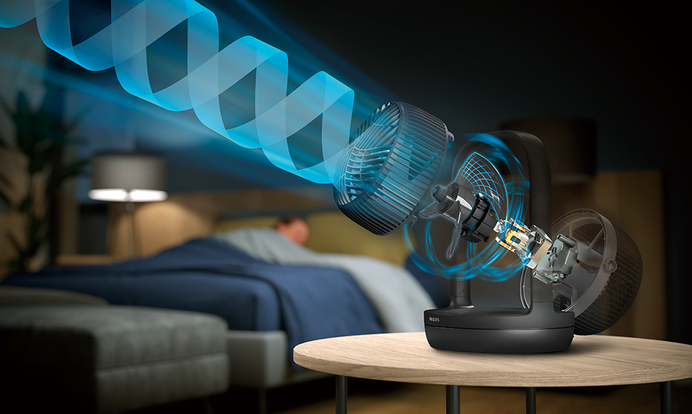 Ventilátor kék légáramlási vonalakkal. Egy személy alszik az ágyban a háttérben.