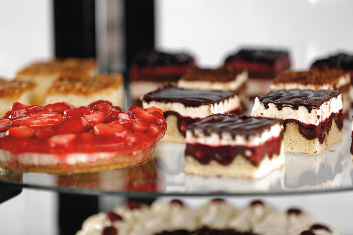 Verschiedene Kuchenstücke und Torten auf einer gläsernen Etagère.