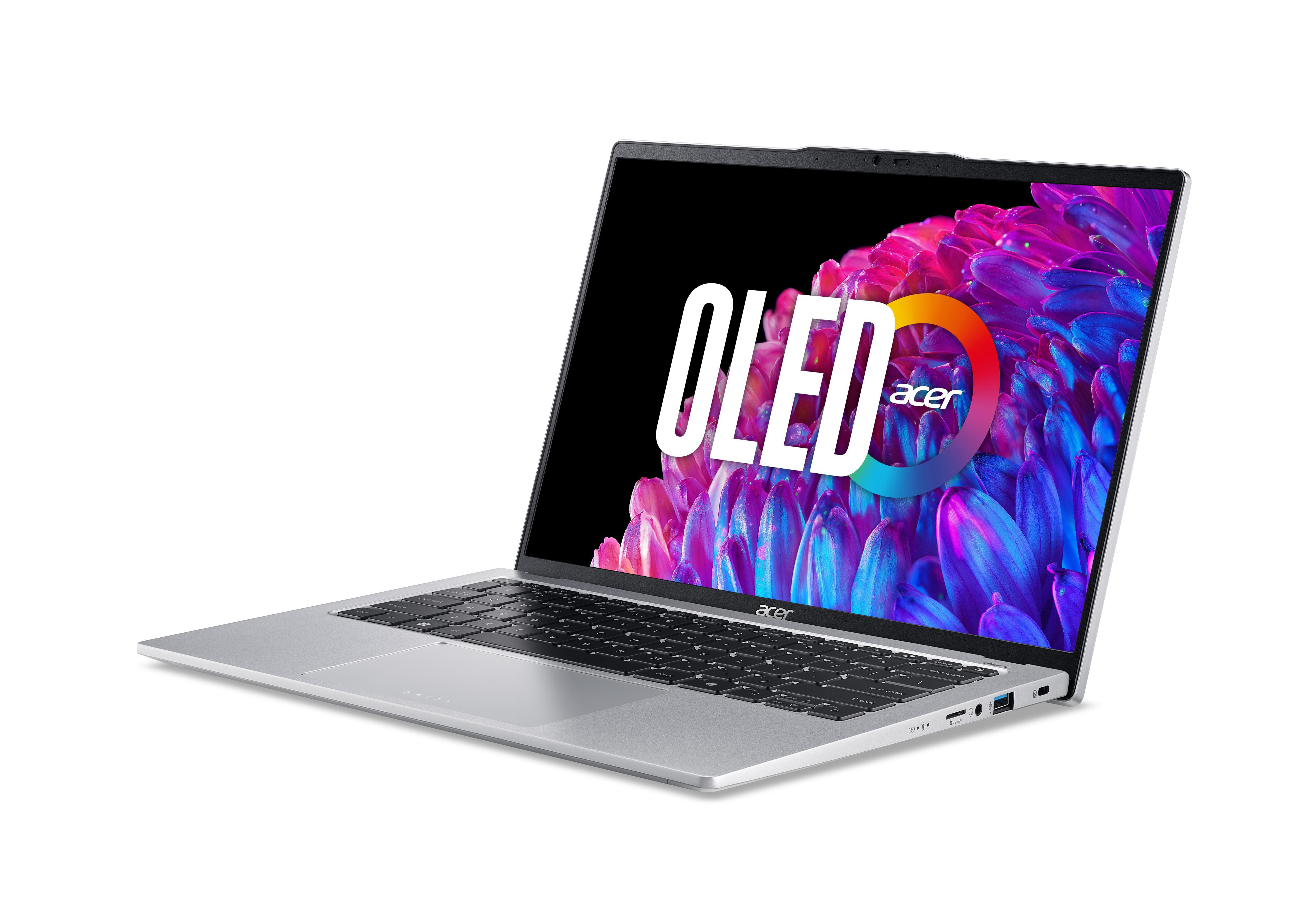Silberner Laptop im Winkel geöffnet. Bildschirm zeigt OLED-Logo. Tastatur sichtbar. Weißer Hintergrund.