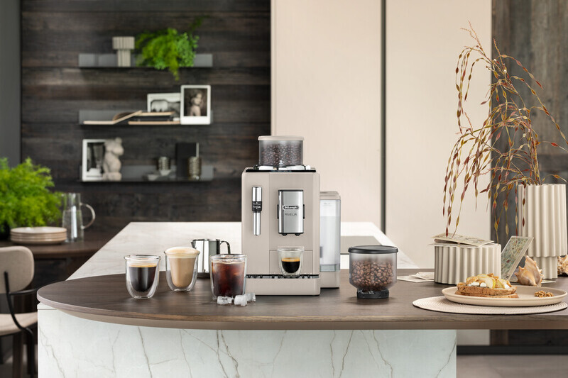 Coffee machine with coffee, beans, and food on a kitchen counter, with a modern design.