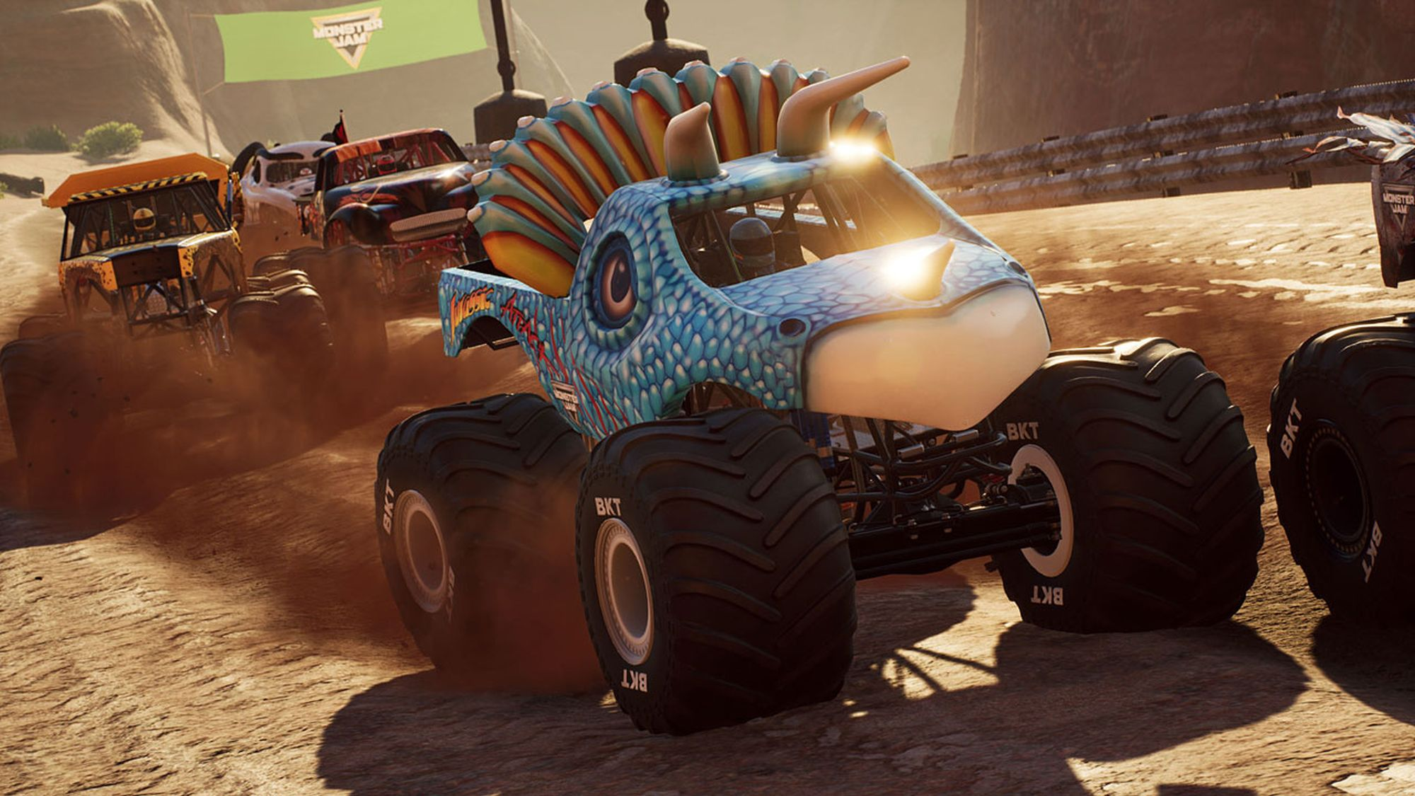 Una gara di monster truck con diversi camion, uno a forma di dinosauro, su una pista sterrata.