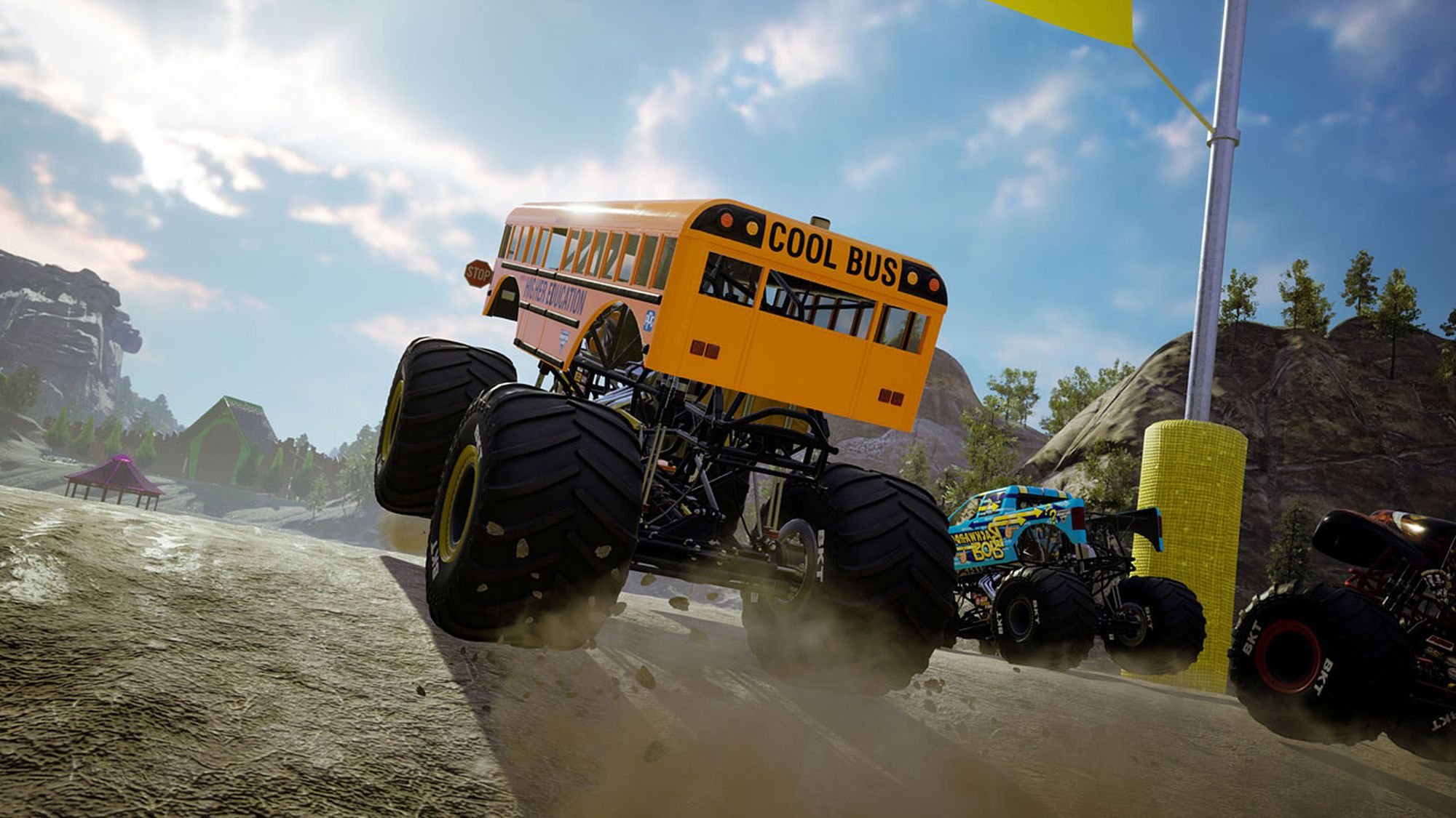 Monster truck arancione, etichettato 'COOL BUS', salta sullo sporco. Cielo blu e altri camion sullo sfondo.