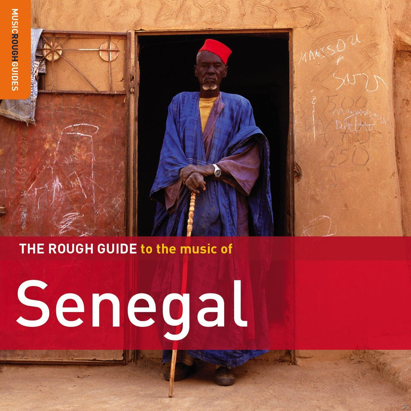 Kék ruhás, piros kalapos férfi, botot tart. Ajtó írással ellátott épületbe vezet. The Rough Guide to the music of Senegal.