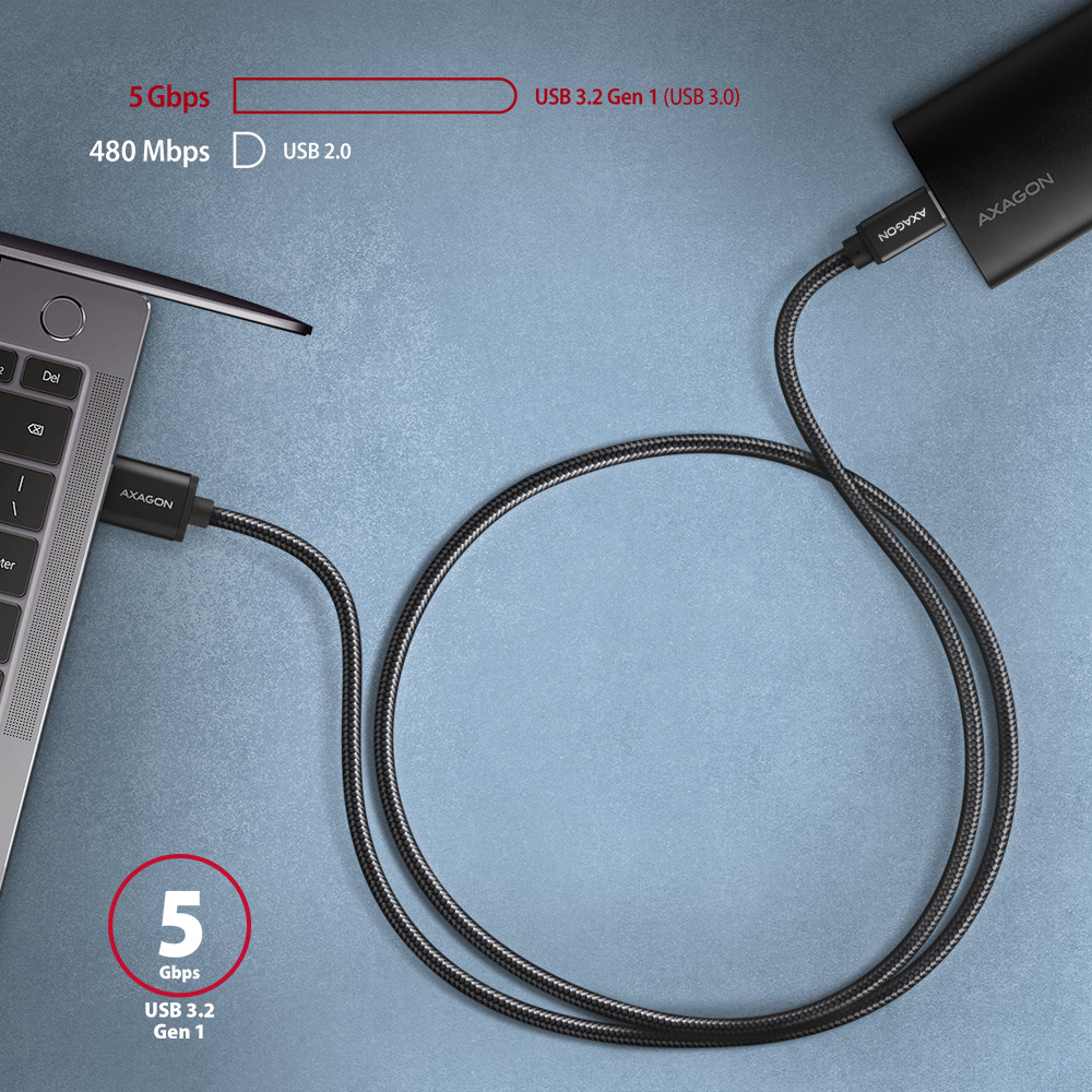 Laptop egy fekete külső merevlemezhez csatlakoztatva USB-kábellel.