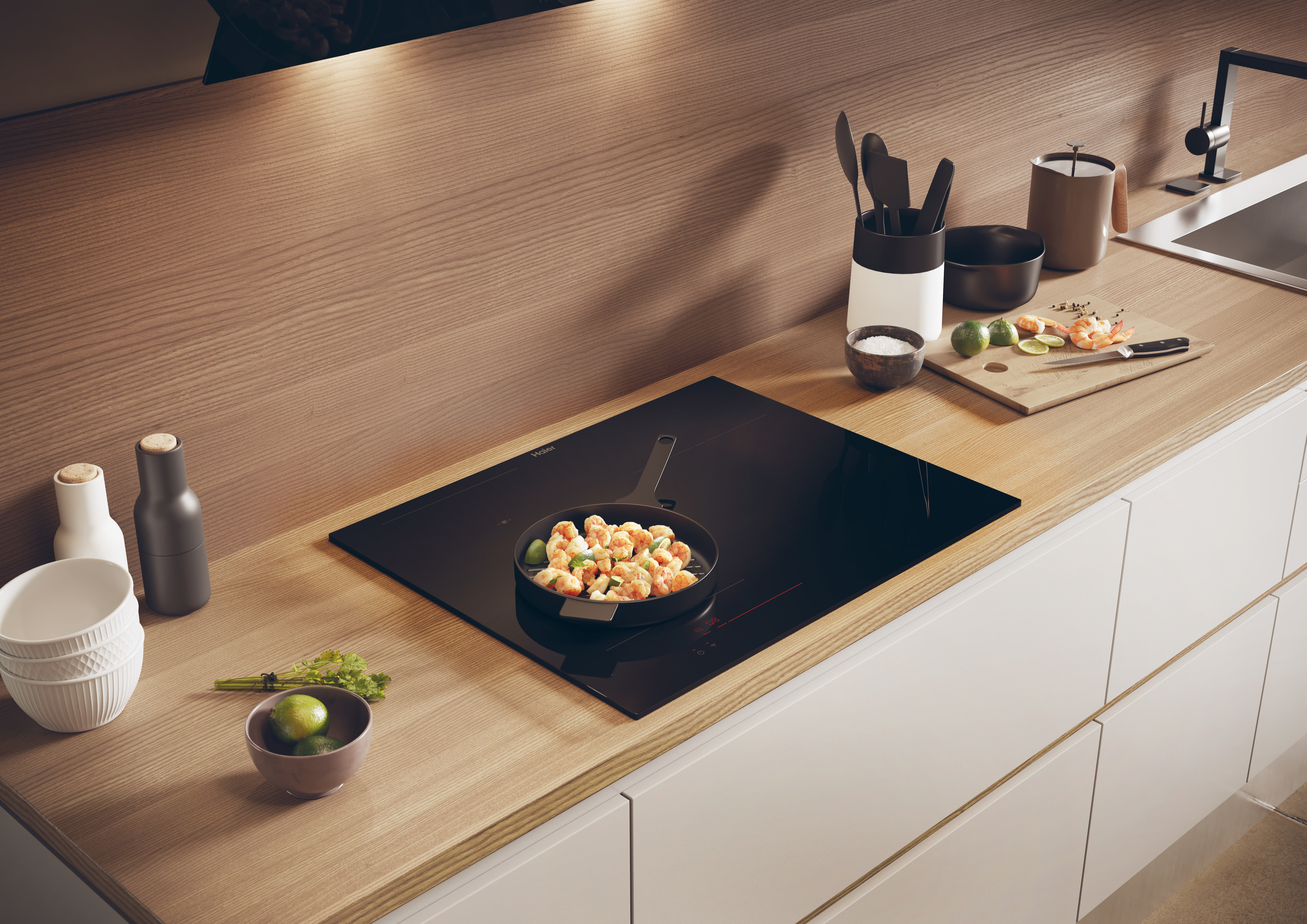 Encimera de cocina con una placa de cocina negra. Se está cocinando una sartén con comida. Otros artículos están presentes.
