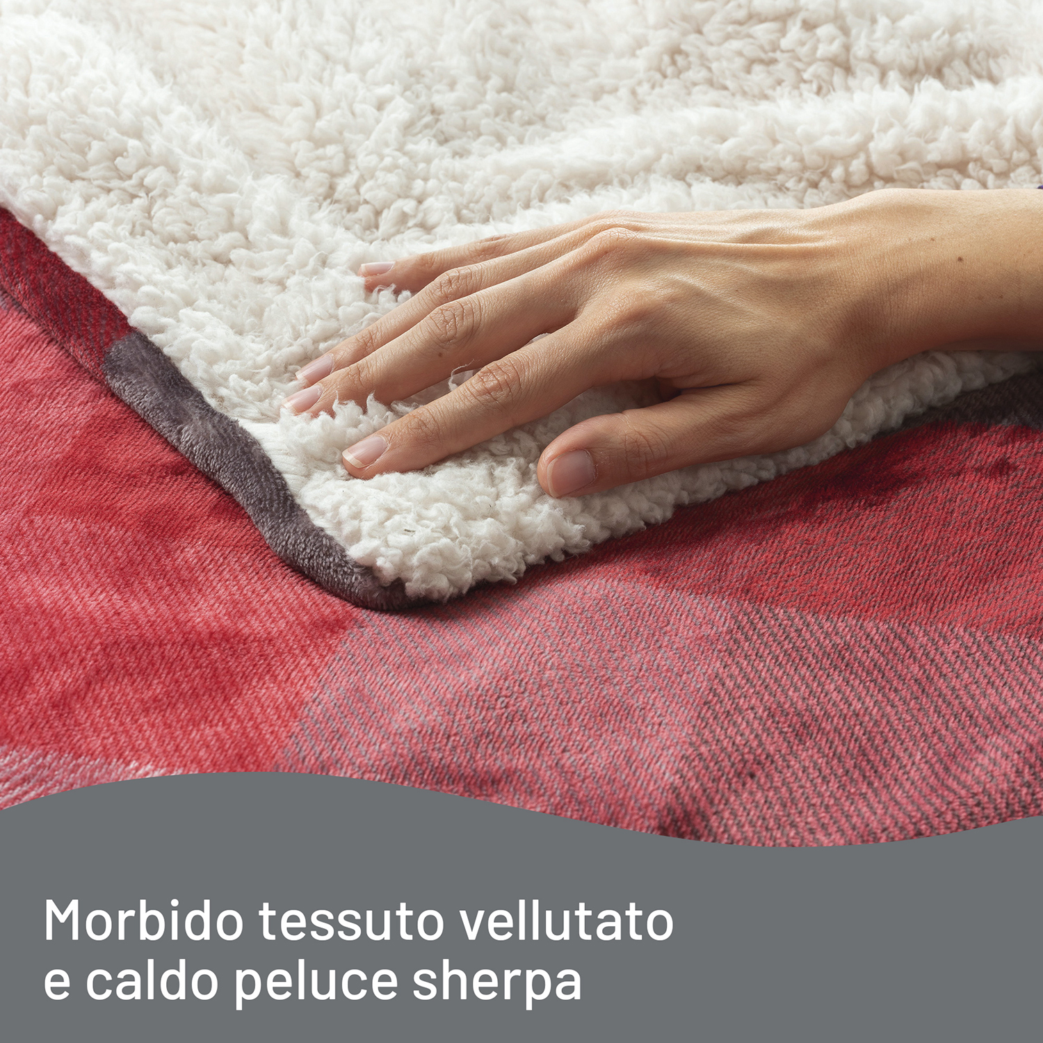 Mano su una morbida coperta sherpa bianca sopra una coperta a quadri rossa e bianca.