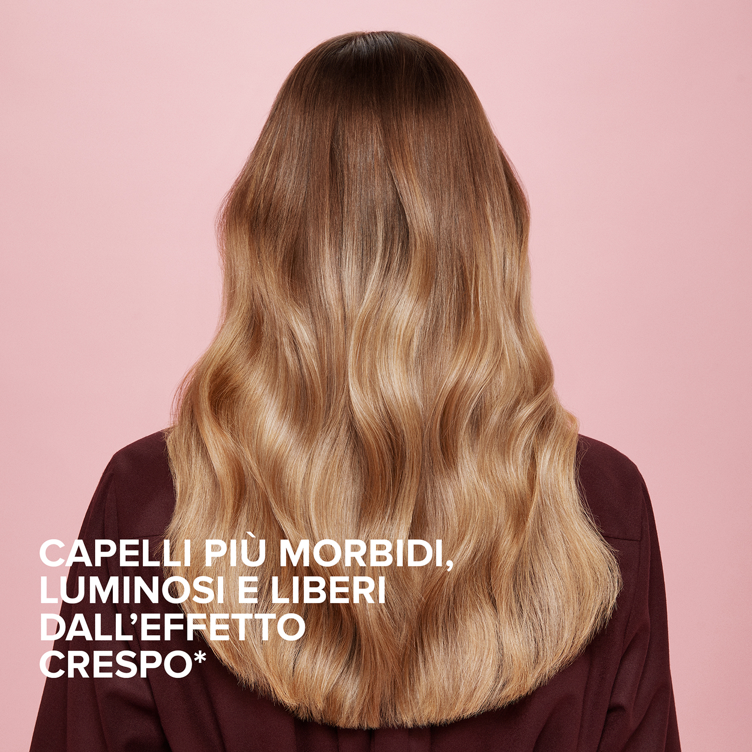 Lunghi capelli ondulati di una donna. I capelli sono un mix di toni marroni e biondo chiaro.