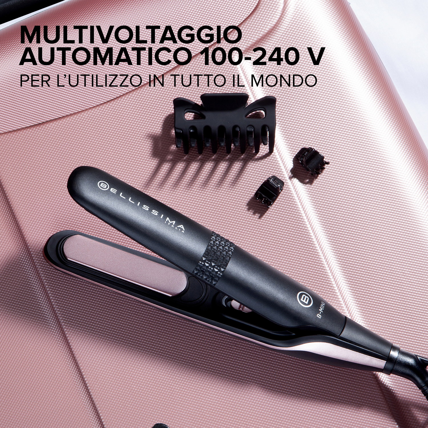 Piastra per capelli e clip su un bagaglio rosa. La piastra è nera e rosa.