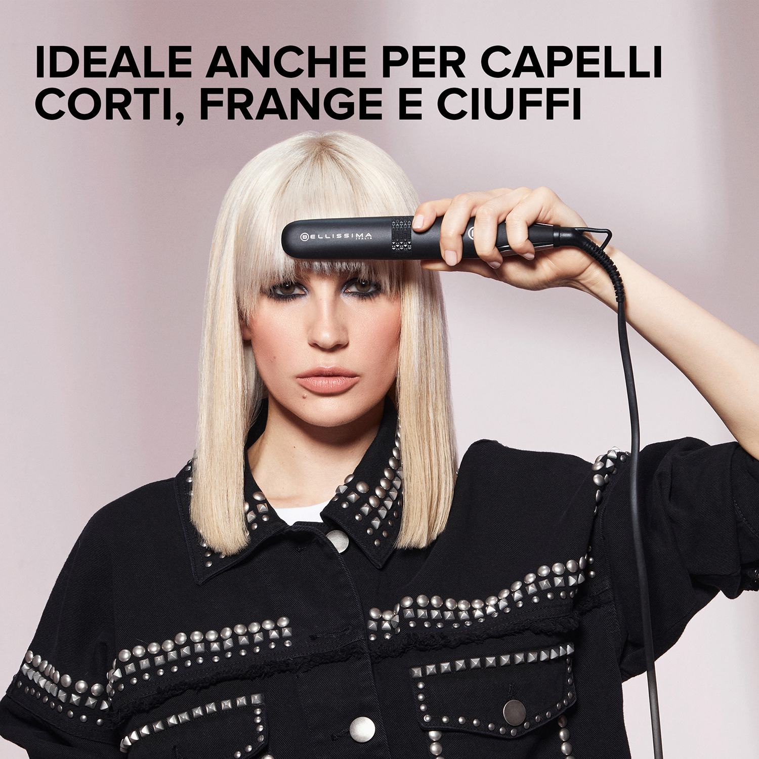 Donna con capelli biondi che usa una piastra, davanti a uno sfondo rosa.