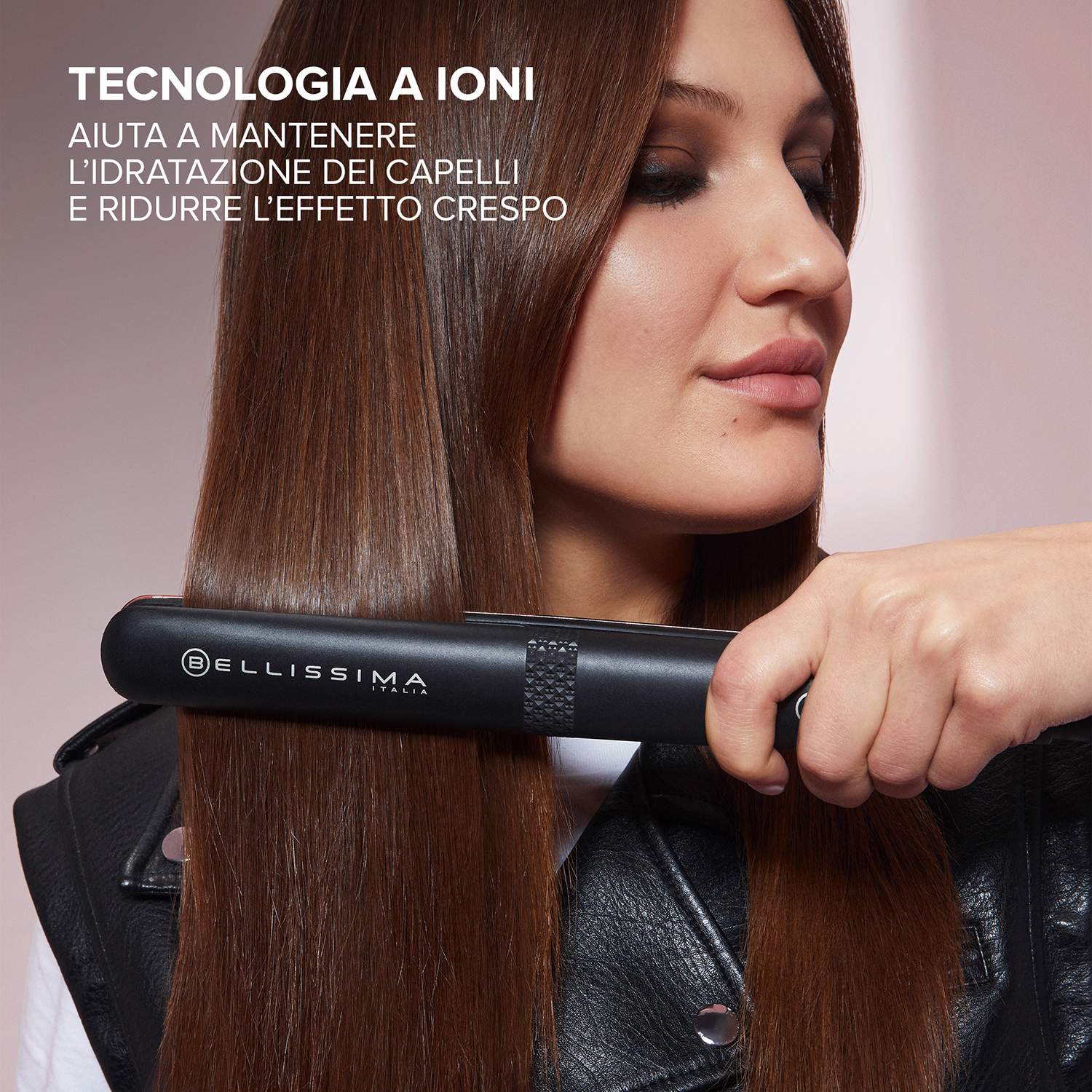 Una donna si sta lisciando i capelli con una piastra nera.