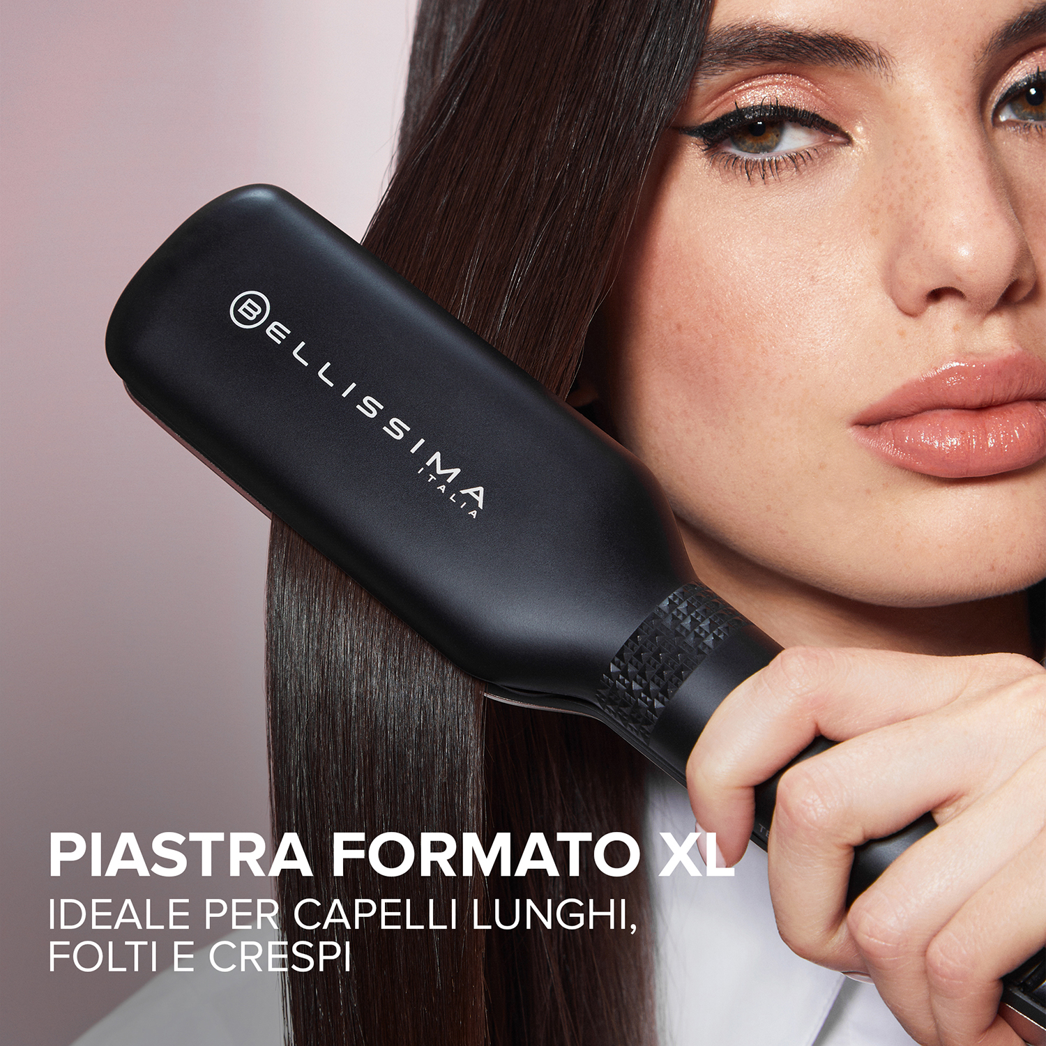 Donna che usa una piastra nera sui suoi capelli scuri. Testo: Formato XL, ideale per capelli lunghi, spessi e ricci.