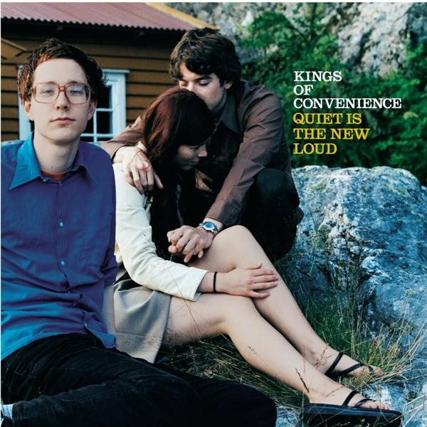 Albumcover mit drei Personen. Zwei umarmen sich auf einem Felsen, einer schaut in die Kamera.