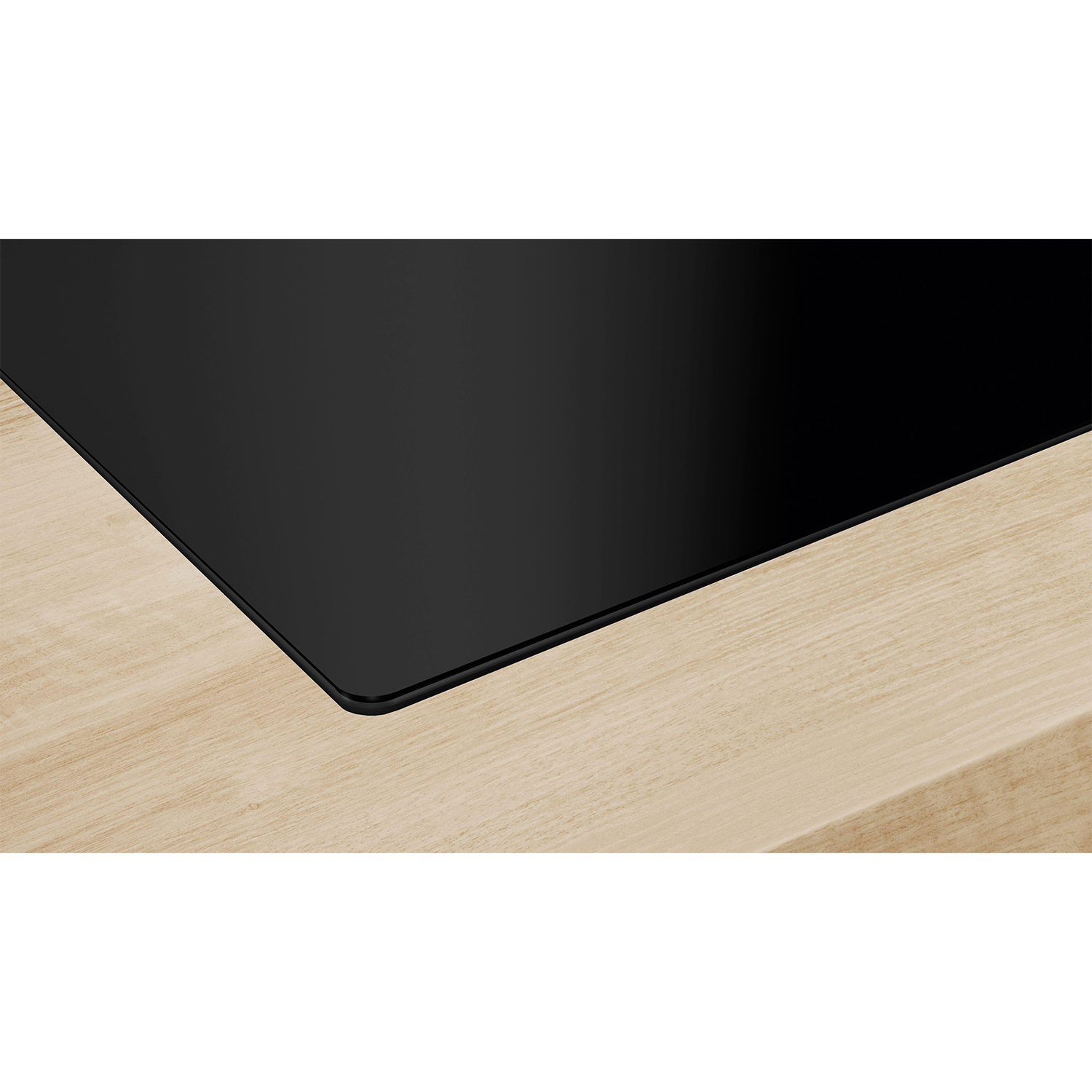Piano cottura nero su superficie in legno, primo piano.