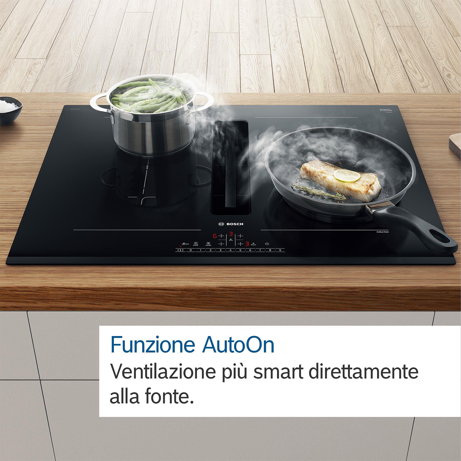 Un piano cottura a induzione nero con pentola e padella, tavolo di legno. Testo AutoOn.