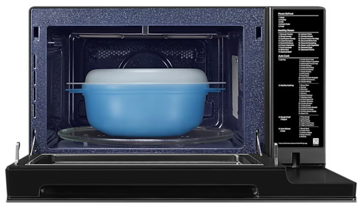 Wnętrze kuchenki mikrofalowej z niebieskim pojemnikiem i szklanym talerzem.