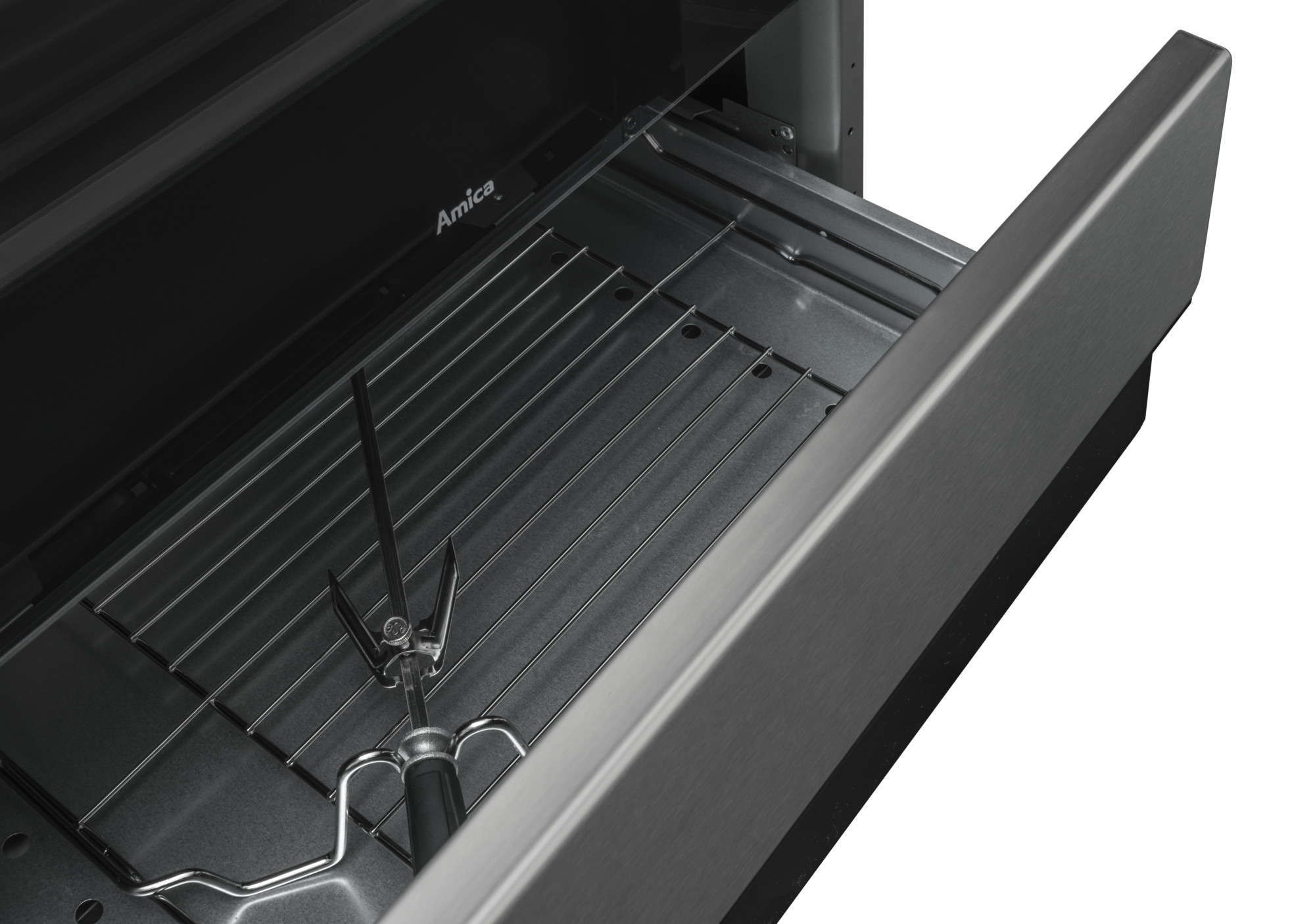 Otwarta szuflada piekarnika z rusztem i mechanizmem rożna. Szuflada i wnętrze ze stali nierdzewnej.