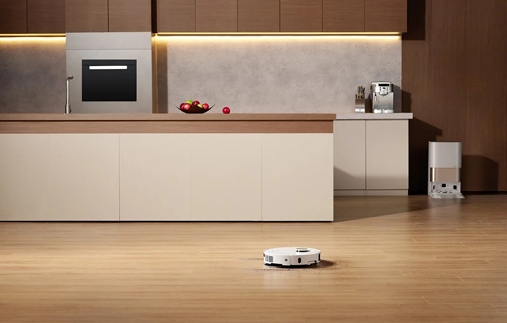 Robot sprzątający na drewnianej podłodze w kuchni.