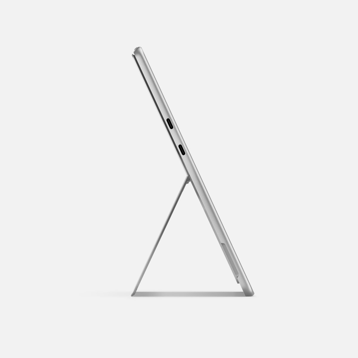 Srebrzysty tablet, widok z boku, podparty stojakiem. Widoczne dwa porty.