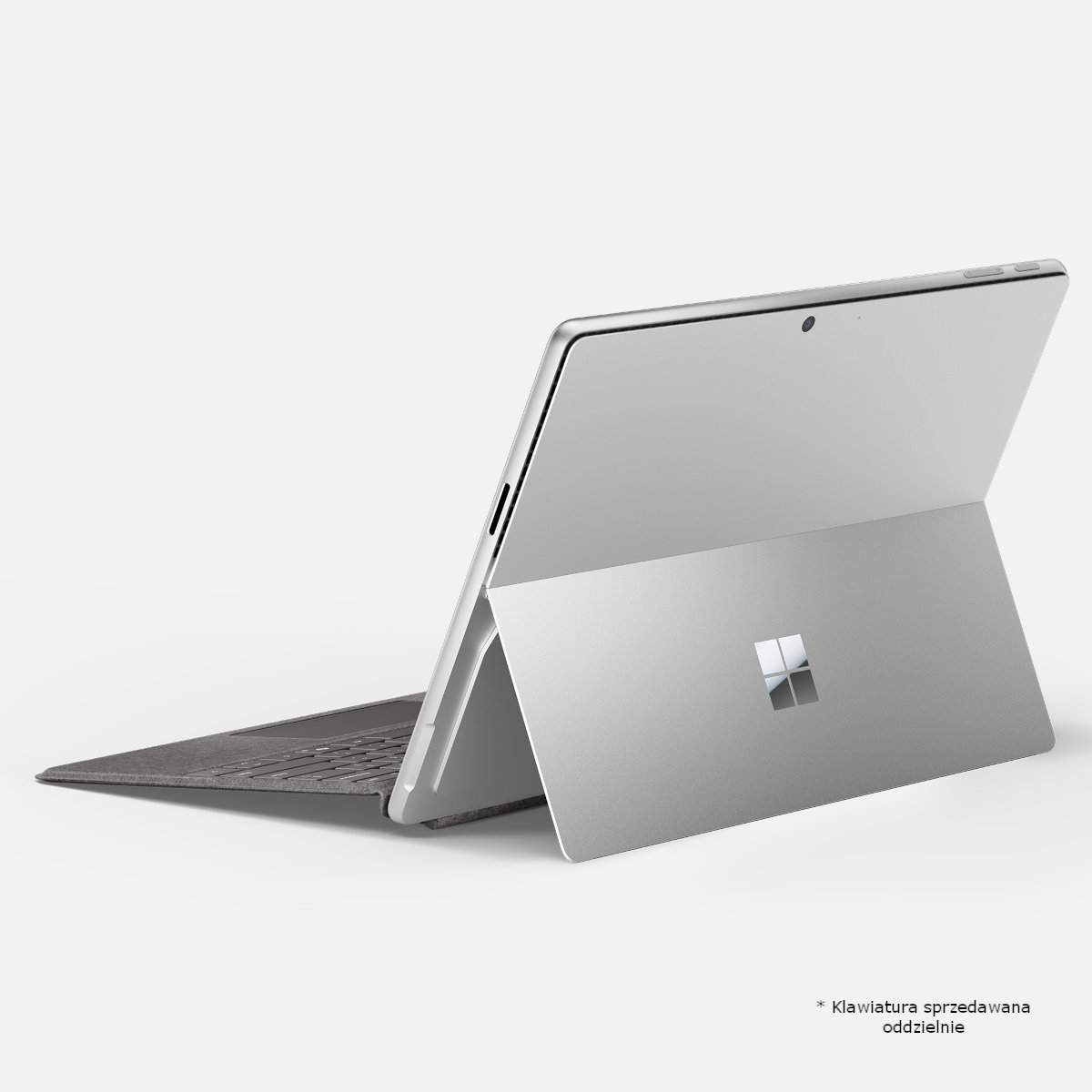Srebrny laptop z klawiaturą i otwartą podstawką. Widoczne logo Microsoft. Białe tło.