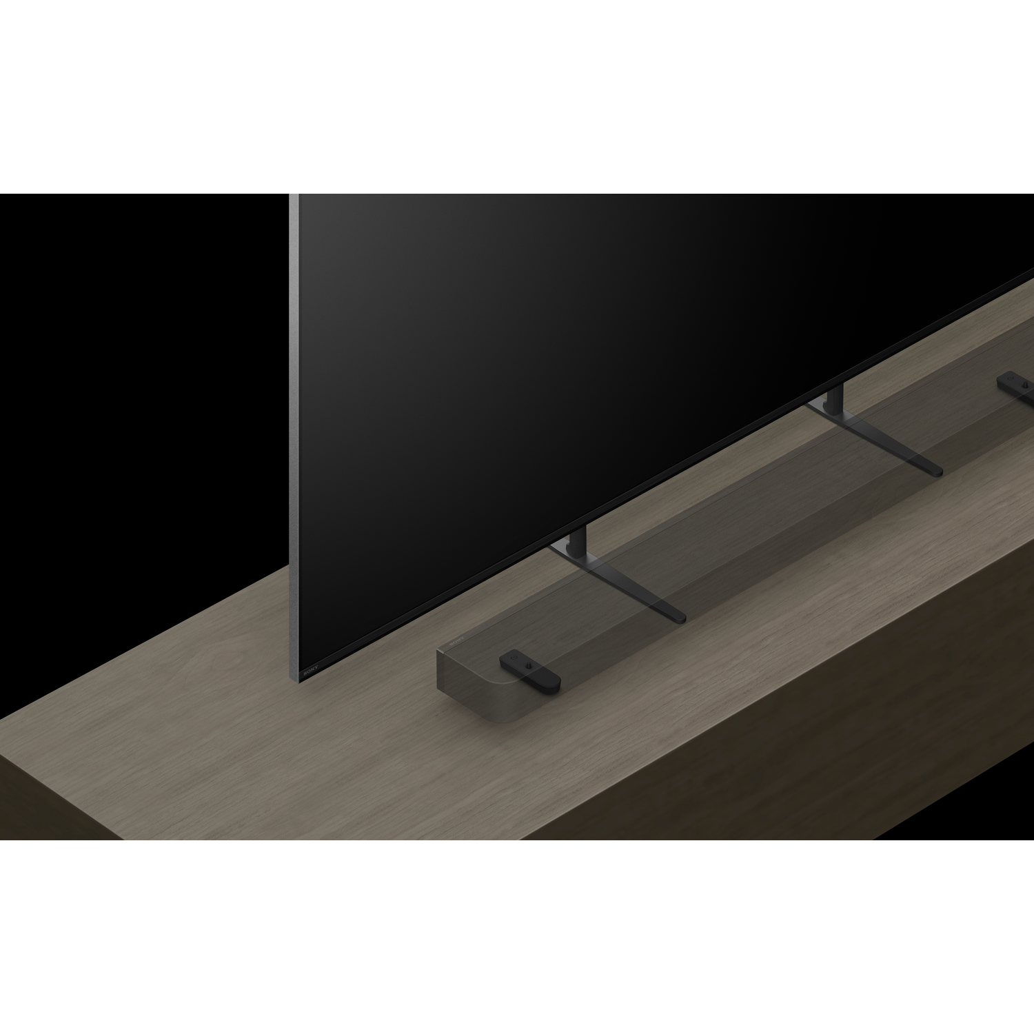 Een tv-scherm op een houten oppervlak met een soundbar en een afstandsbediening.