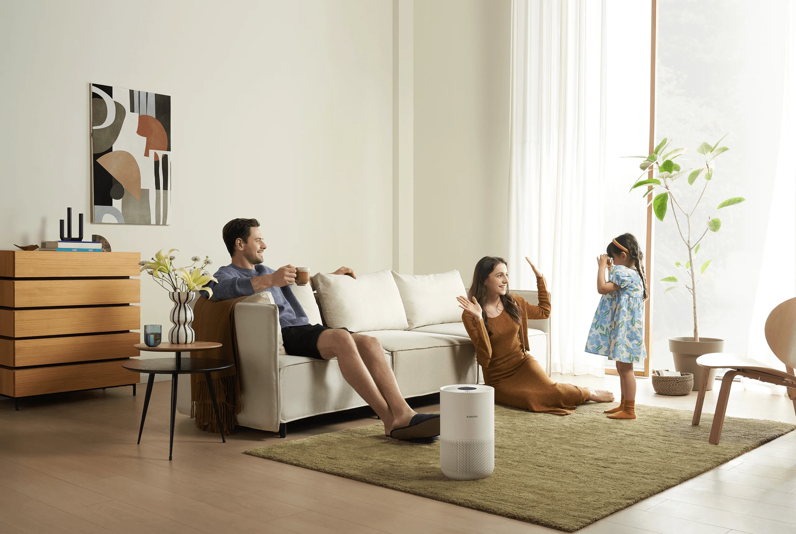 Famille dans le salon, femme et homme assis sur le canapé, fille jouant.
