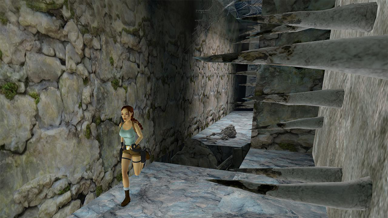 Lara Croft rennt in einem Steinkorridor. Stachelige Decke. Spielszene.