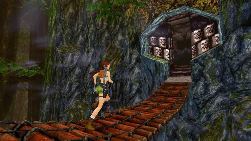 Lara Croft rennt auf einer Holzbrücke in einer dschungelartigen Spielumgebung.