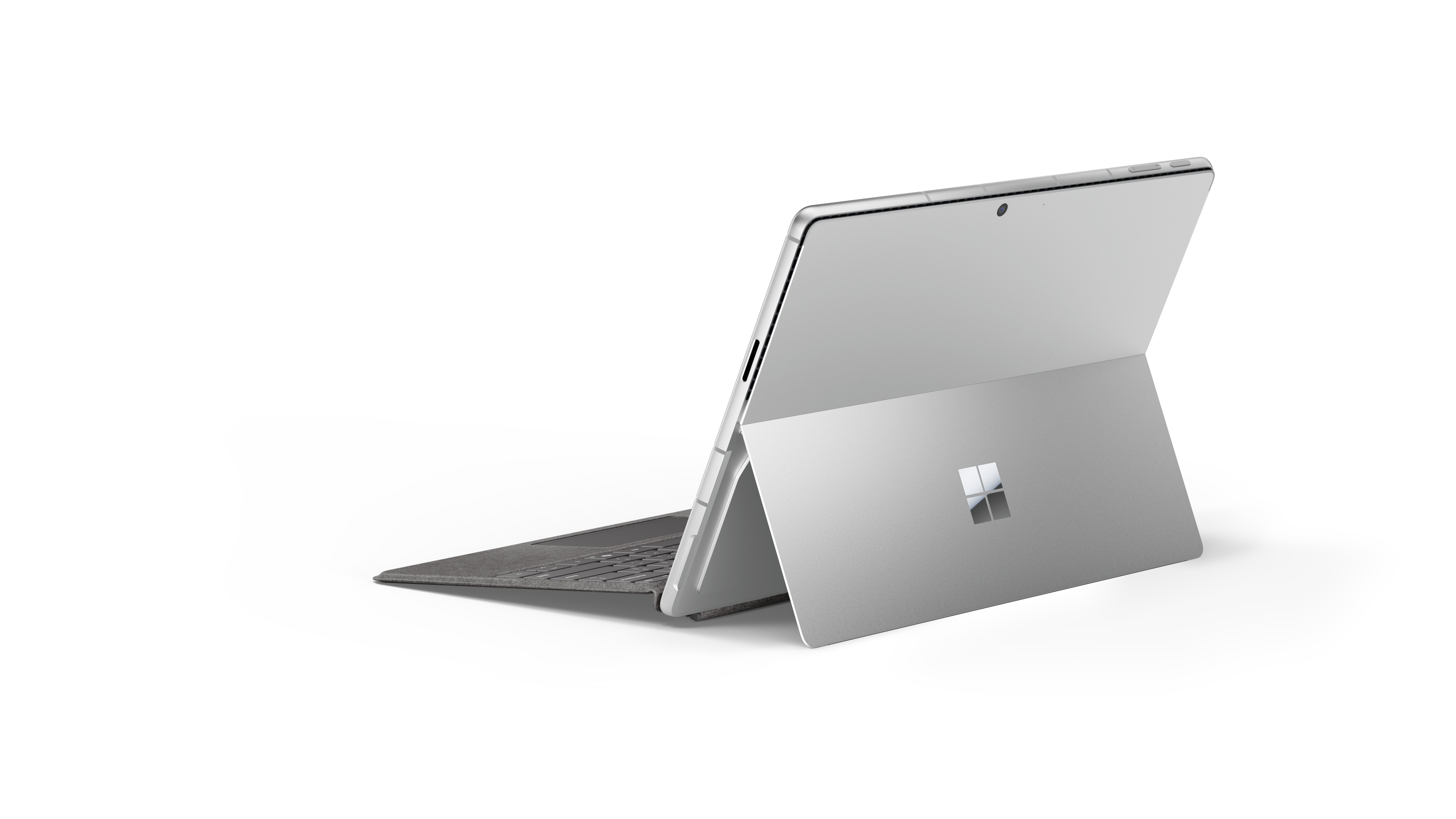 Silberner Laptop, offen, auf weißer Oberfläche, weißer Hintergrund.