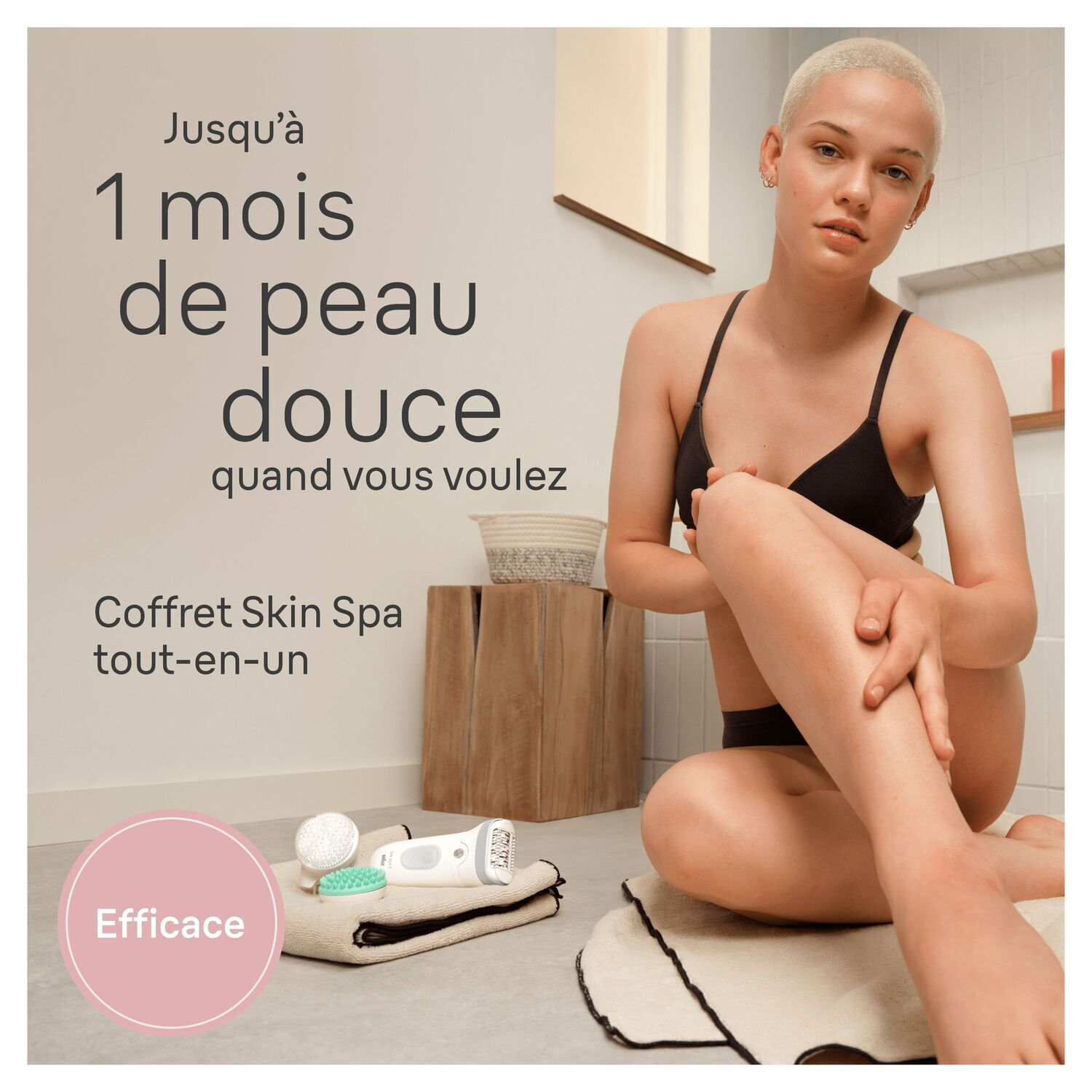 Femme assise, tenant sa jambe, dans une salle de bain. Texte : '1 mois de peau douce'.