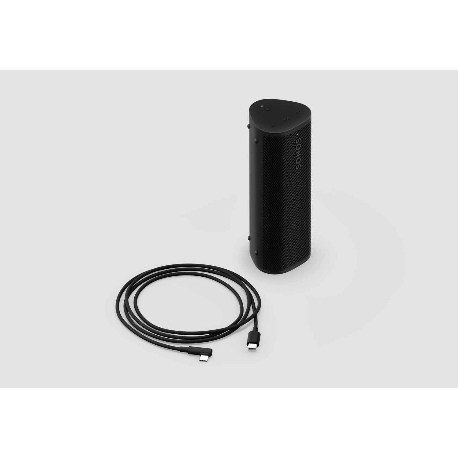 Een zwarte speaker en een zwarte kabel met USB-C-connectoren op een wit oppervlak.