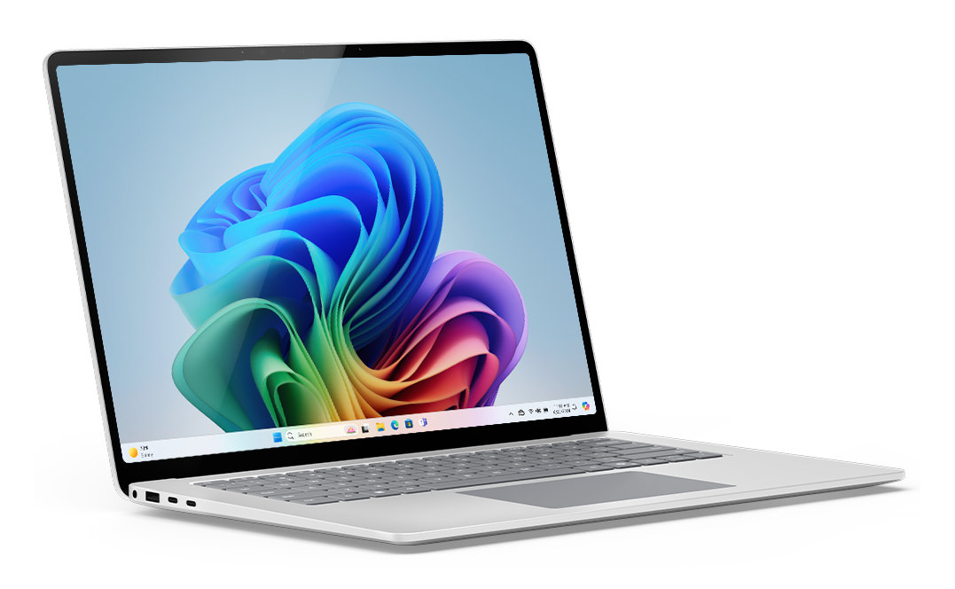 Srebrny laptop z otwartą pokrywą, pokazujący kolorowy wyświetlacz, białe tło.