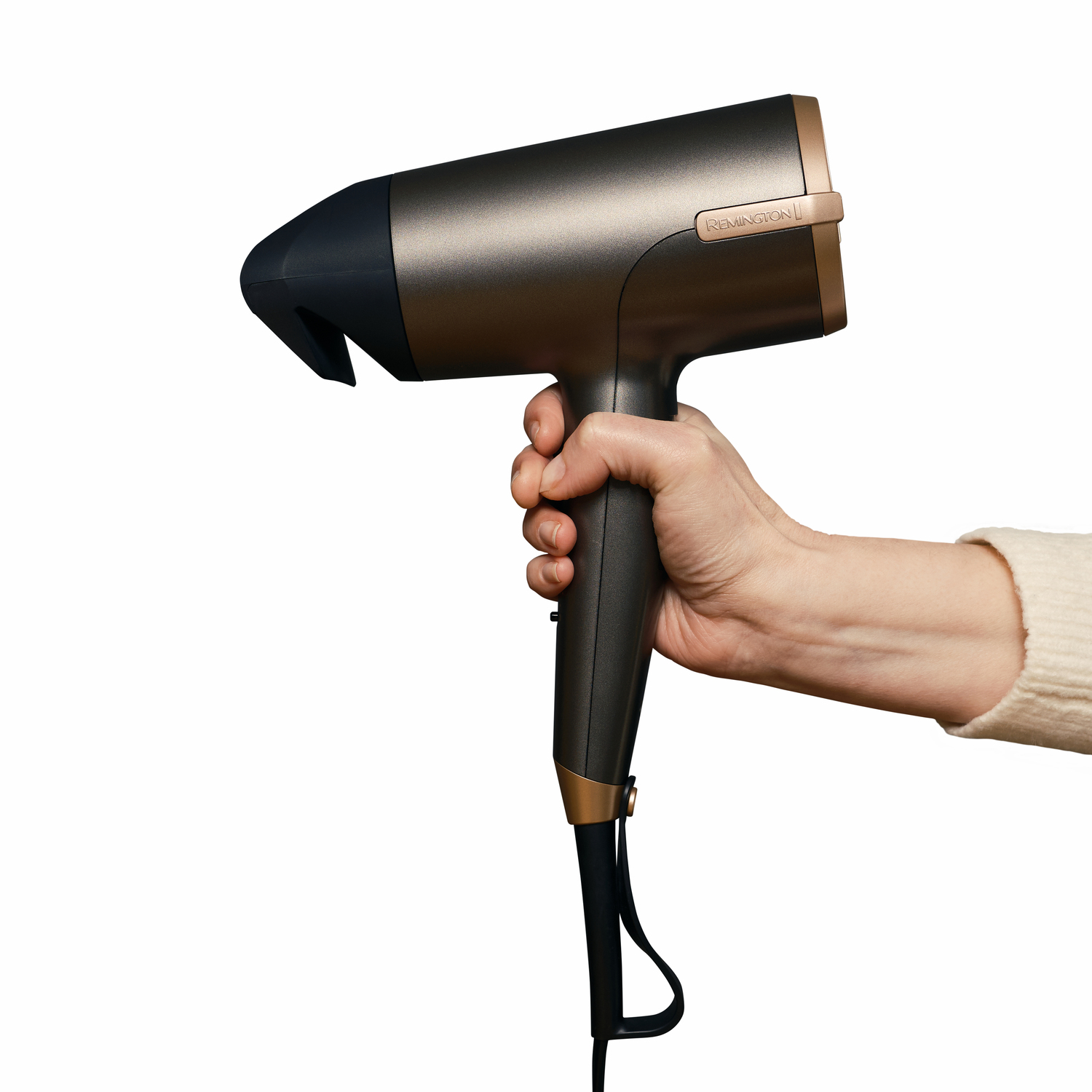 Hand die een bronzen en zwarte haardroger vasthoudt. Witte achtergrond.