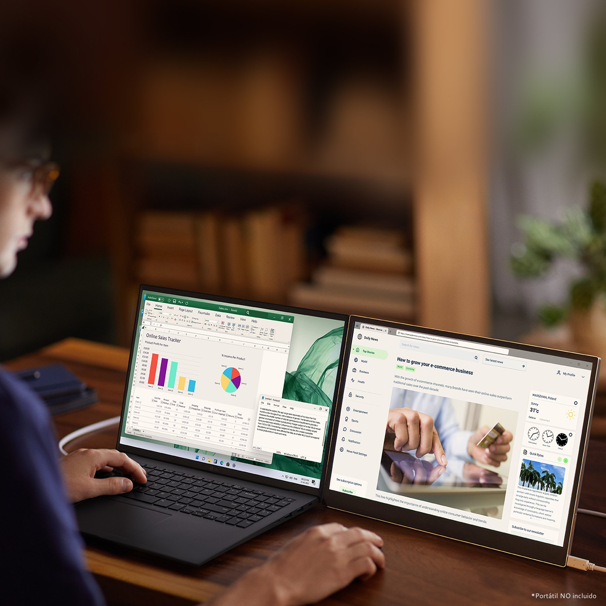 Hombre usa portátil con una segunda pantalla mostrando información de negocios.