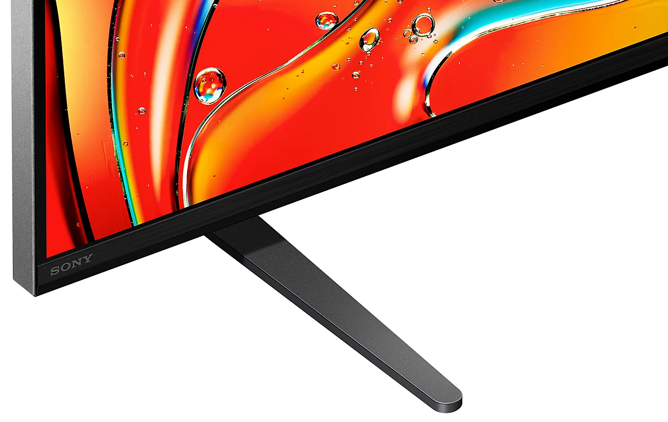 Zbliżenie na czarną podstawę telewizora, szarą metalową stronę i ekran telewizora wyświetlający kolorowe wzory.