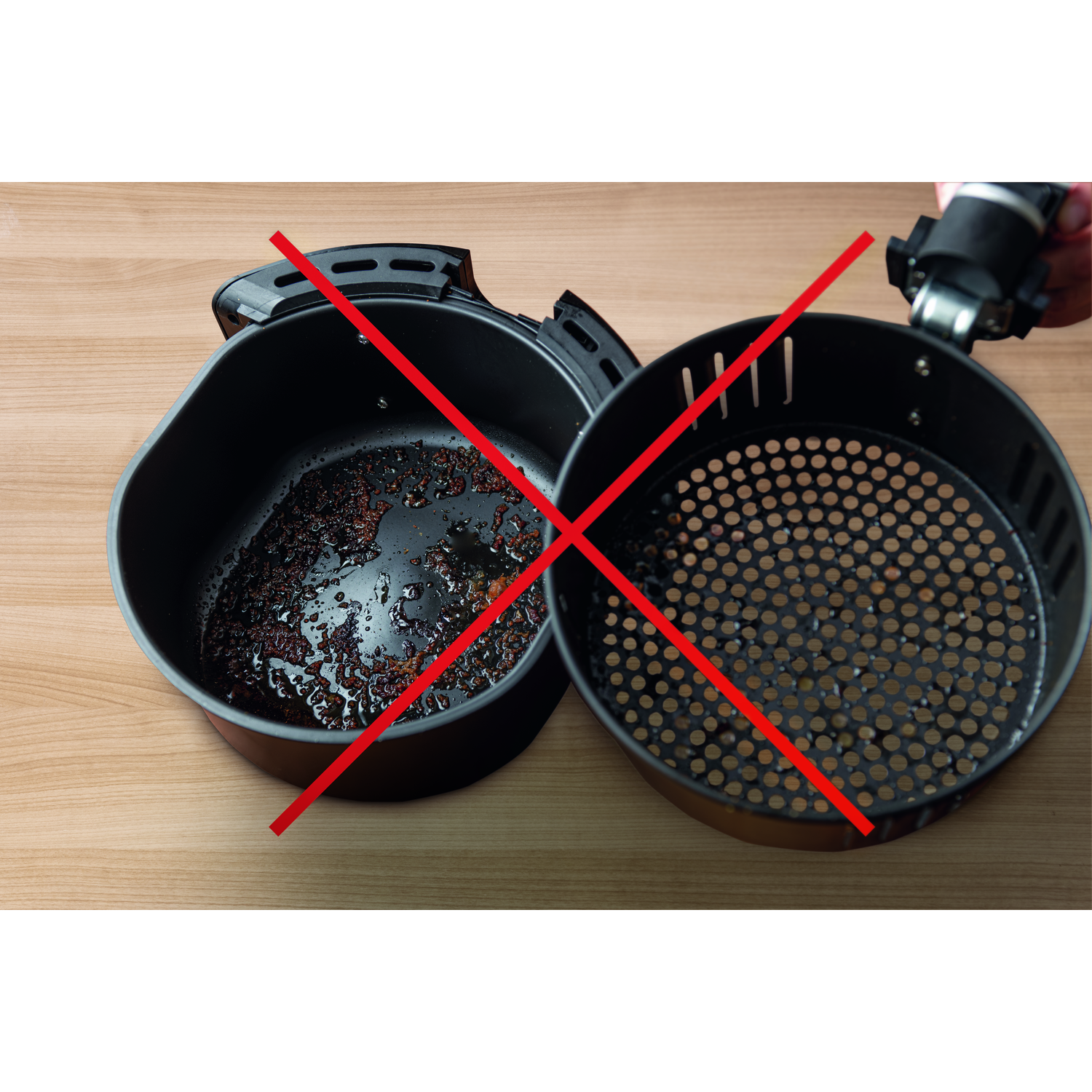 An air fryer with the basket removed, showing burnt food, with red crosses over both parts.