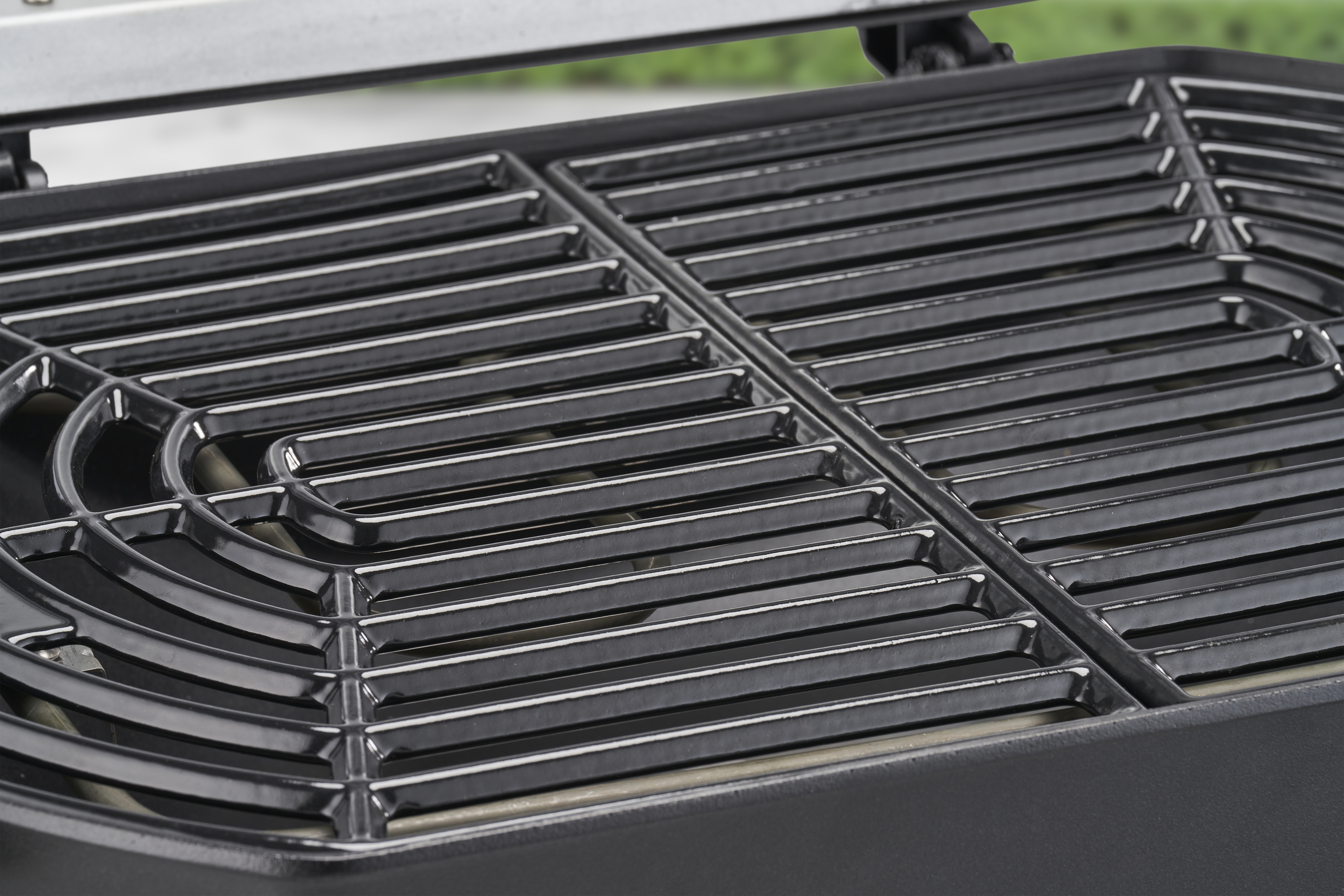 Nahaufnahme eines Grillrosts. Schwarzes Metall mit parallelen Stangen. Dunkler Hintergrund.