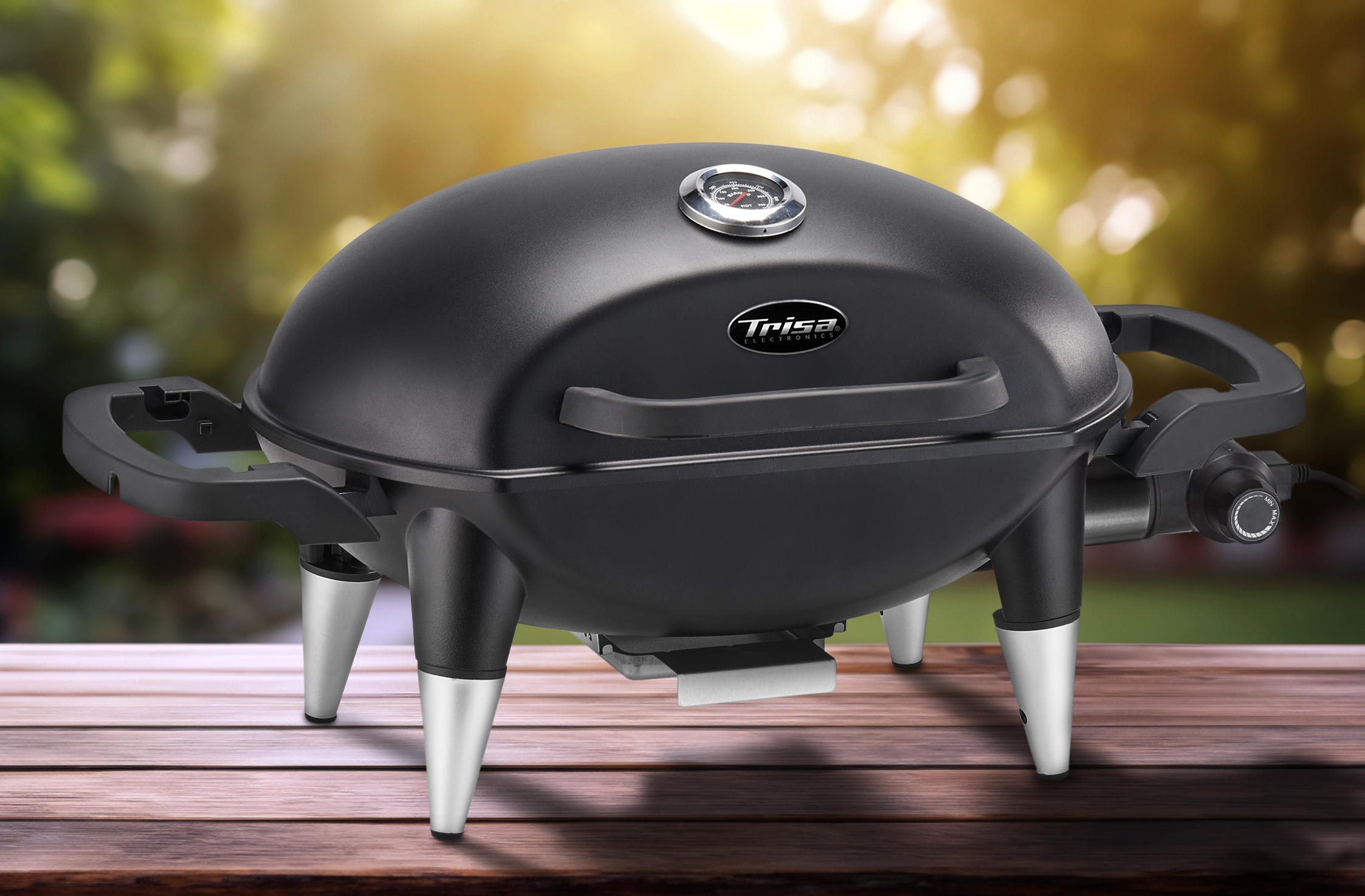 Ein schwarzer, tragbarer Grill auf einer Holzoberfläche mit verschwommenem Hintergrund.