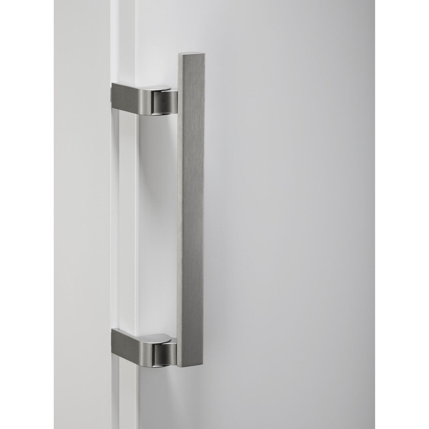 A close-up of a white door handle, brushed silver.